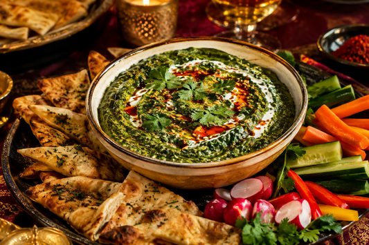 Creamy Indian spiced spinach dip with naan chips, vegetables, cilantro, and chili oil